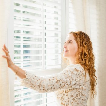 woman next to window blinds