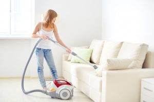 woman vacuuming sofa